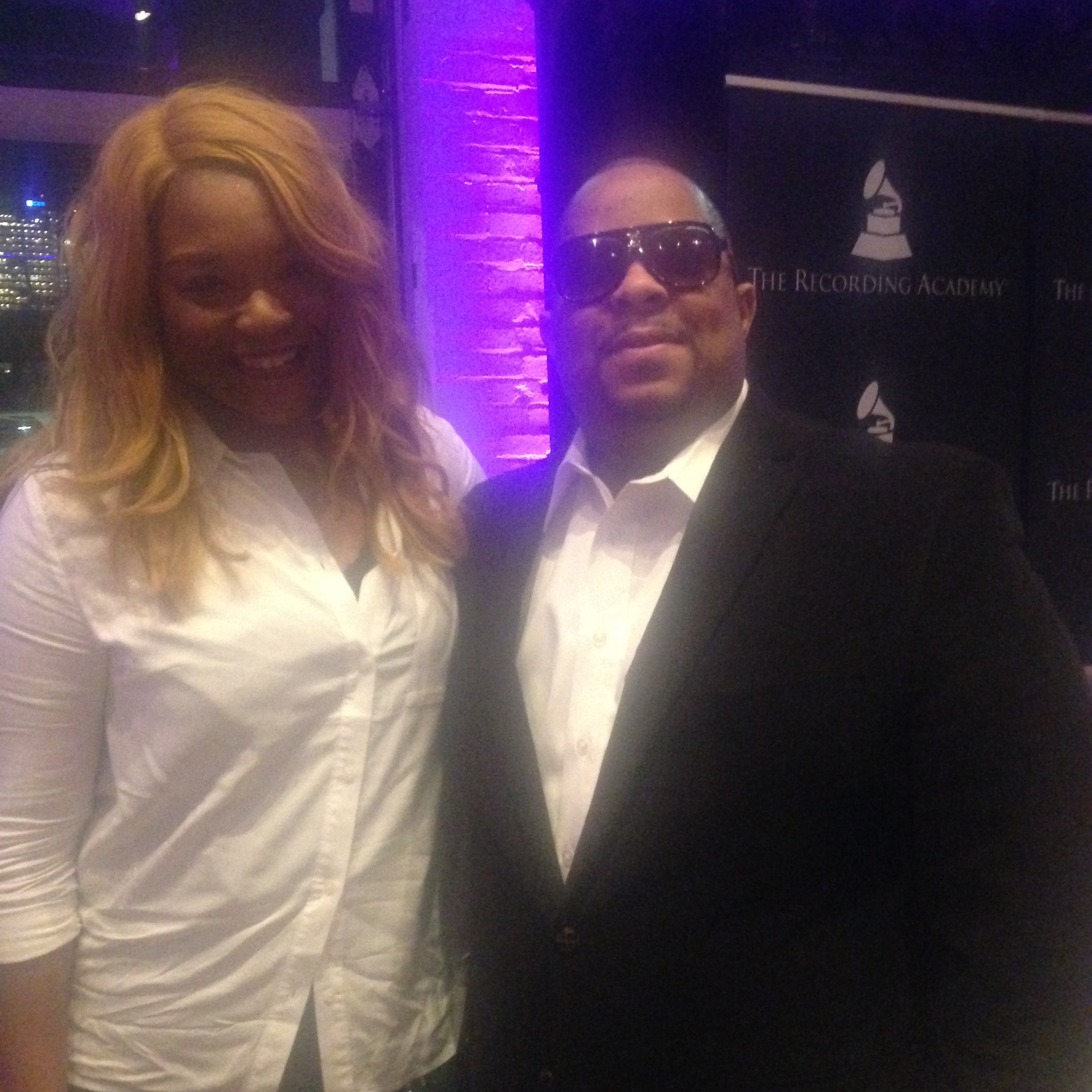 Two people at the Recording Academy event with purple lighting