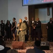 John Tillery leading worship with choir on stage