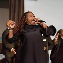 Vocalist performing with choir in black formal attire