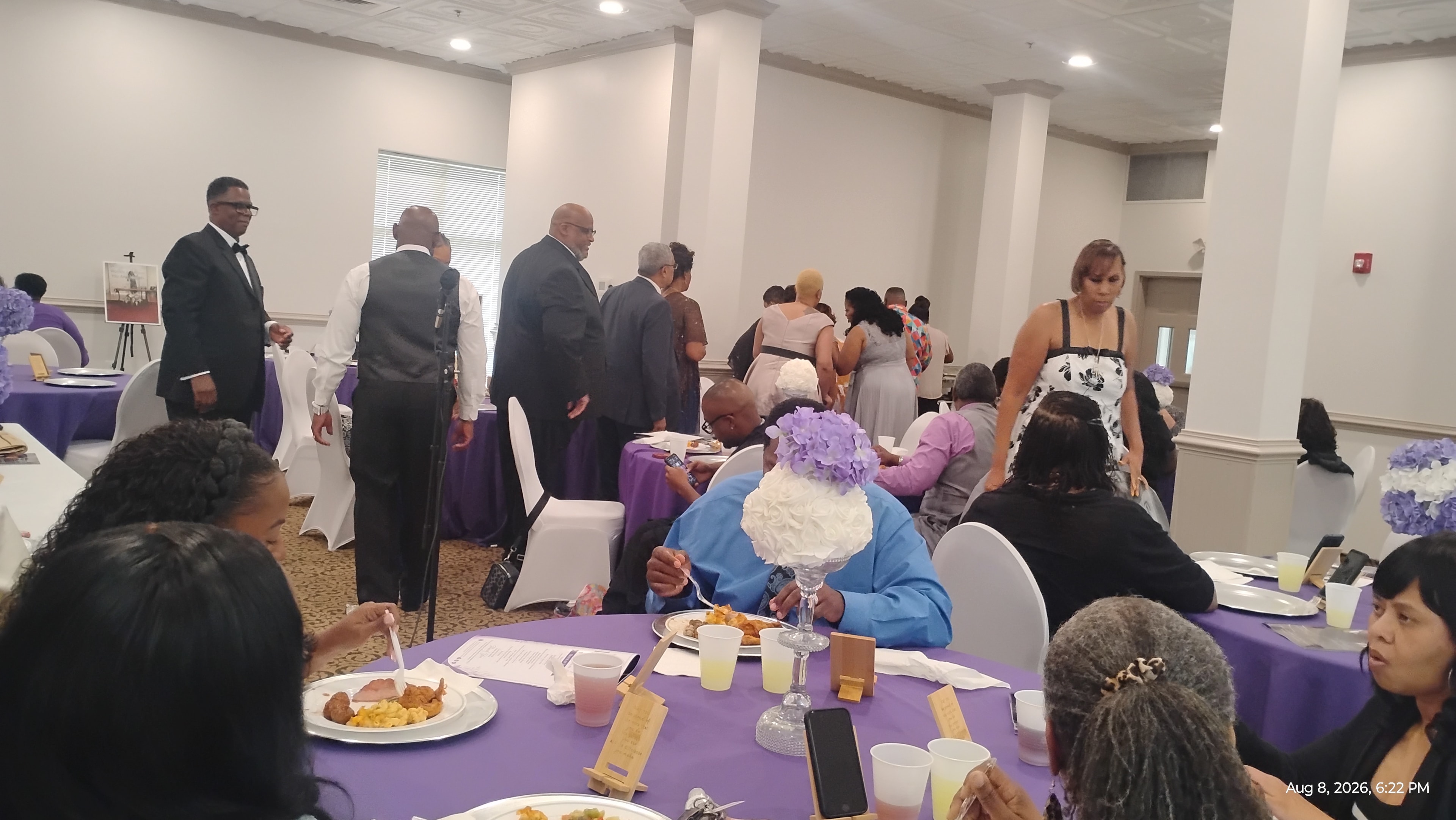 Banquet hall event with purple linens and guests dining