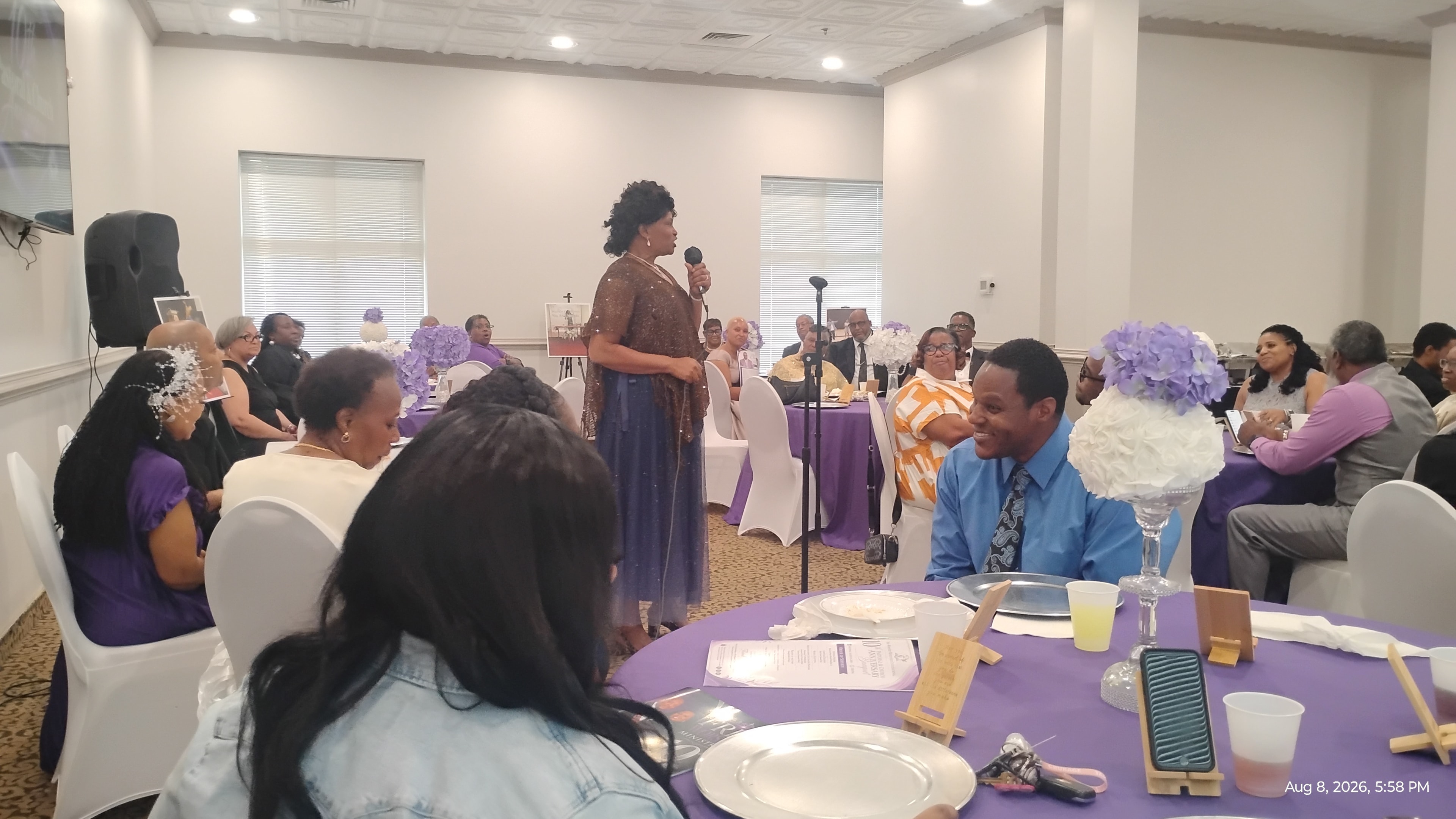 Banquet event with woman speaking at microphone to seated guests