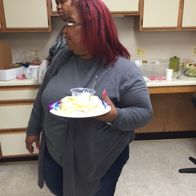 Woman with red hair carrying a birthday cake at a ministry event