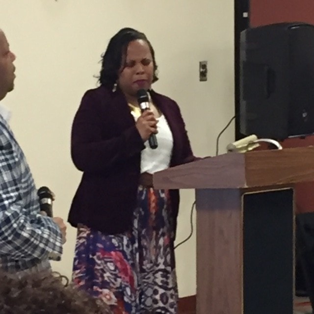 Woman speaking at a podium during a ministry service