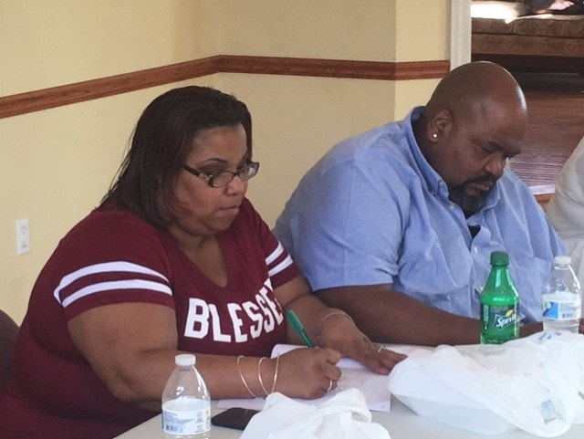 Two people at table taking notes at ministry meeting