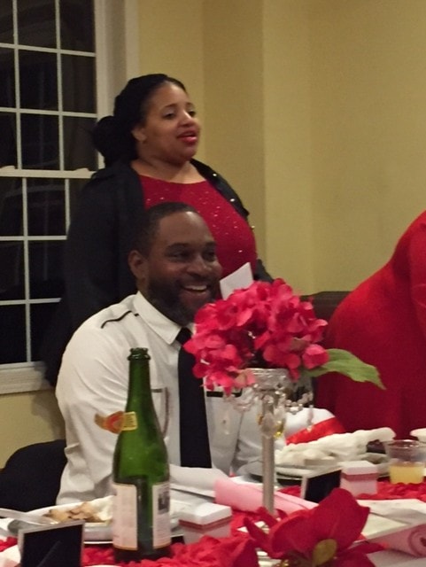 Man and woman at formal dinner with red floral décor