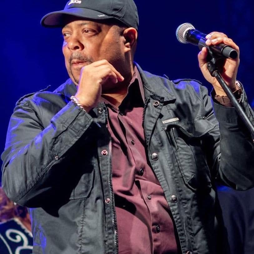 Pastor John Tillery performing on stage with microphone