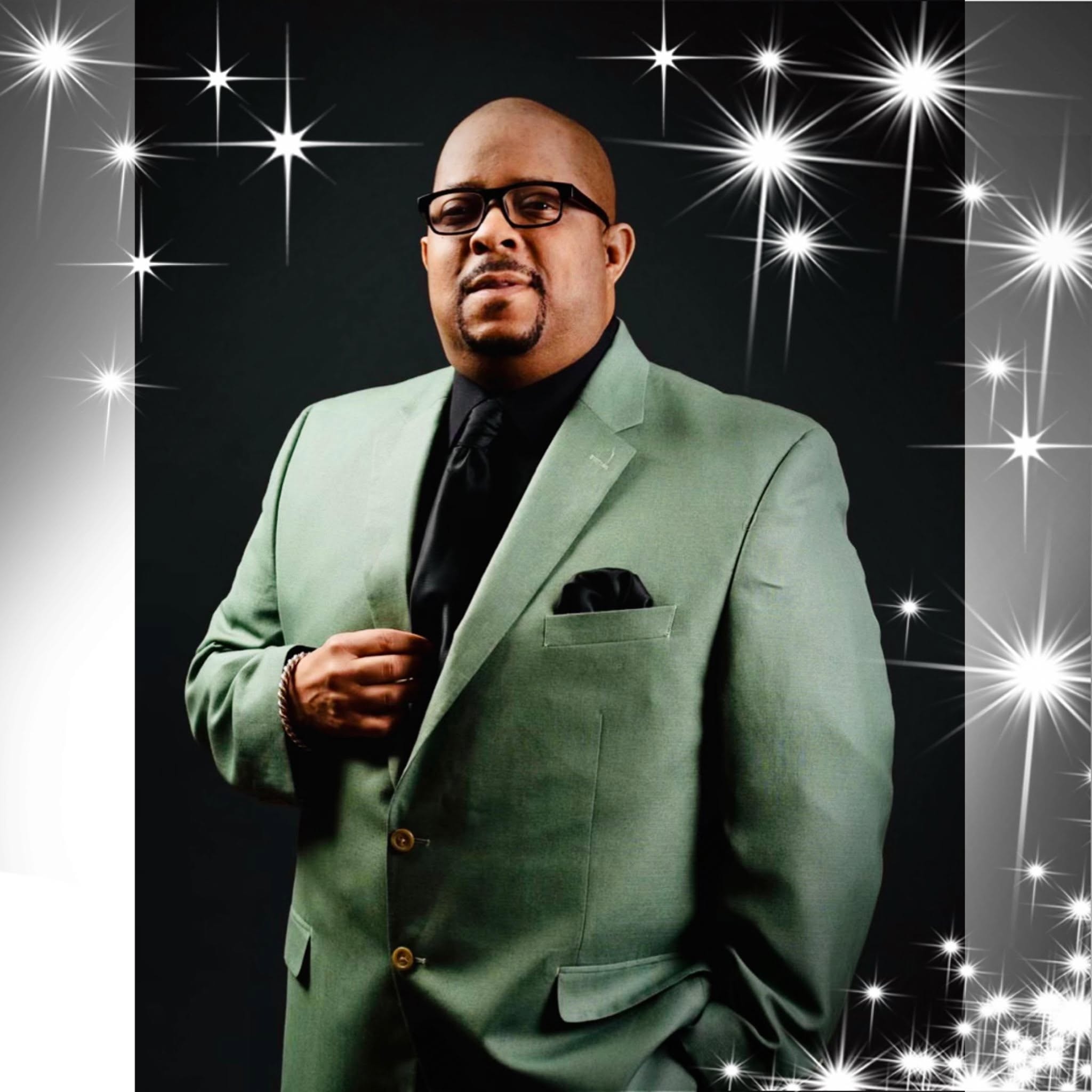 Pastor Tillery in sage green blazer with sparkle star background