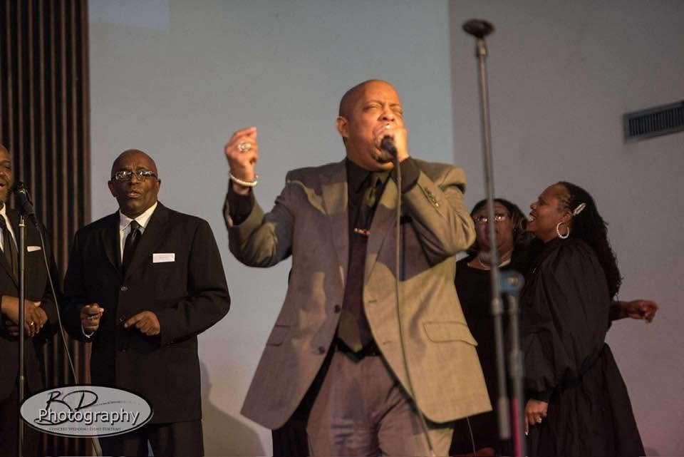 John Tillery singing passionately at Free Worship Ministries with choir