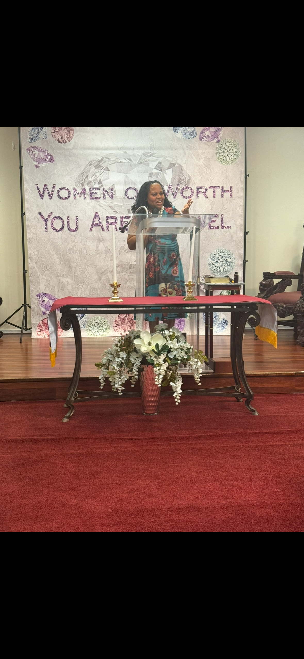 Lady Tillery speaking at Women of Worth podium with diamond backdrop